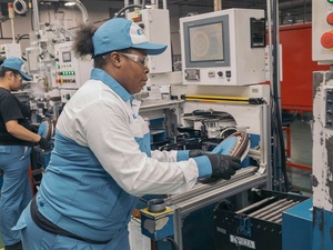 Una obrera trabajando con maquinaria en una fábrica.