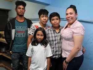 Una familia posa para una foto sonriendo.