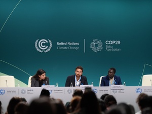 Una mujer y dos hombres intervienen en una sesión de la COP29