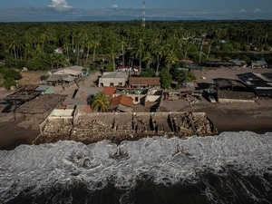 Vista aérea de la costa donde se ven los restos de una casa invadidos por el mar.