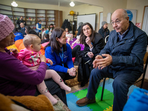 El Alto Comisionado de la ONU para los Refugiados, Barham Salih (a la derecha), habla con Nina (a la izquierda) en un centro de tránsito en Zaporizhzhia, al sureste de Ucrania, después de que ella fuera evacuada de su casa dañada por las bombas junto con su hija y sus tres nietos.