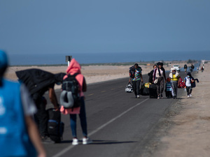 Familias venezolanas recorren una carretera paralela a la frontera con Chile, en la región de Tacna, al sur de Perú (3 de diciembre de 2021).