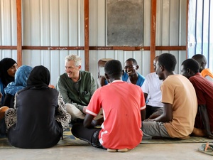 El Alto Comisionado Filippo Grandi sentado con un grupo de jóvenes refugiados sudaneses