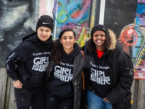 Un grupo de tres mujeres con sudaderas negras posan para la foto