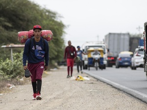 Ángelo, venezolano de 22 años, camina por la carretera Panamericana hacia Tumbes, en Perú, en diciembre de 2021.
