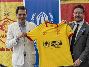 Giovanni Bassu, Representante de ACNUR en Ecuador, y Julián Pástor, Gerente General de Sociedad Deportiva Aucas, muestran la camiseta oficial del club de fútbol quiteño para el año 2023, tras la firma de un acuerdo que promoverá la inclusión de las personas refugiadas a través del deporte.
