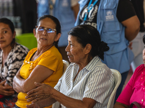 Cuatro mujeres, sentadas una al lado de la otra. Una de ellas está hablando, mientras el resto la escucha.