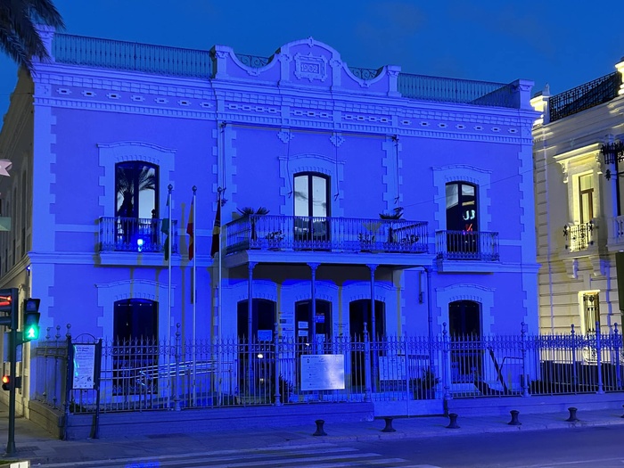 El edificio de la empresa municipal Eressan, en Sanlúcar de Barrameda, iluminado de azul en la víspera del Día Mundial del Refugiado.