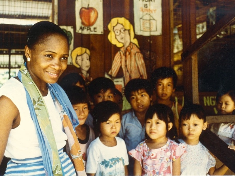 Una mujer afroestadunidense acompañada de un grupo de niñas y niños vietnamitas