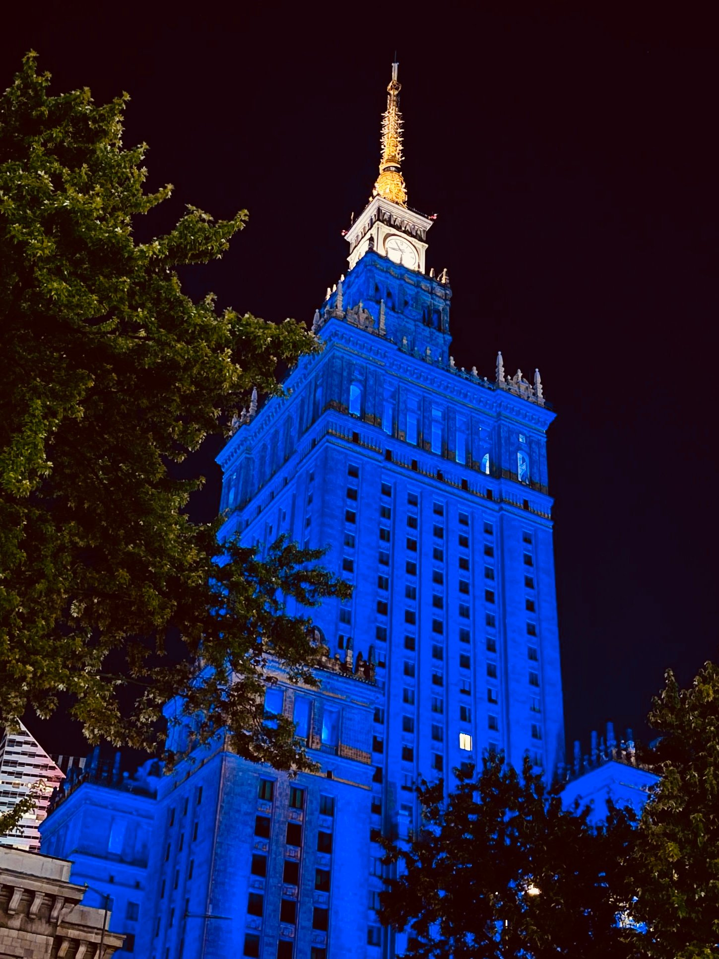Edificio iluminado de azul y la punta blanca