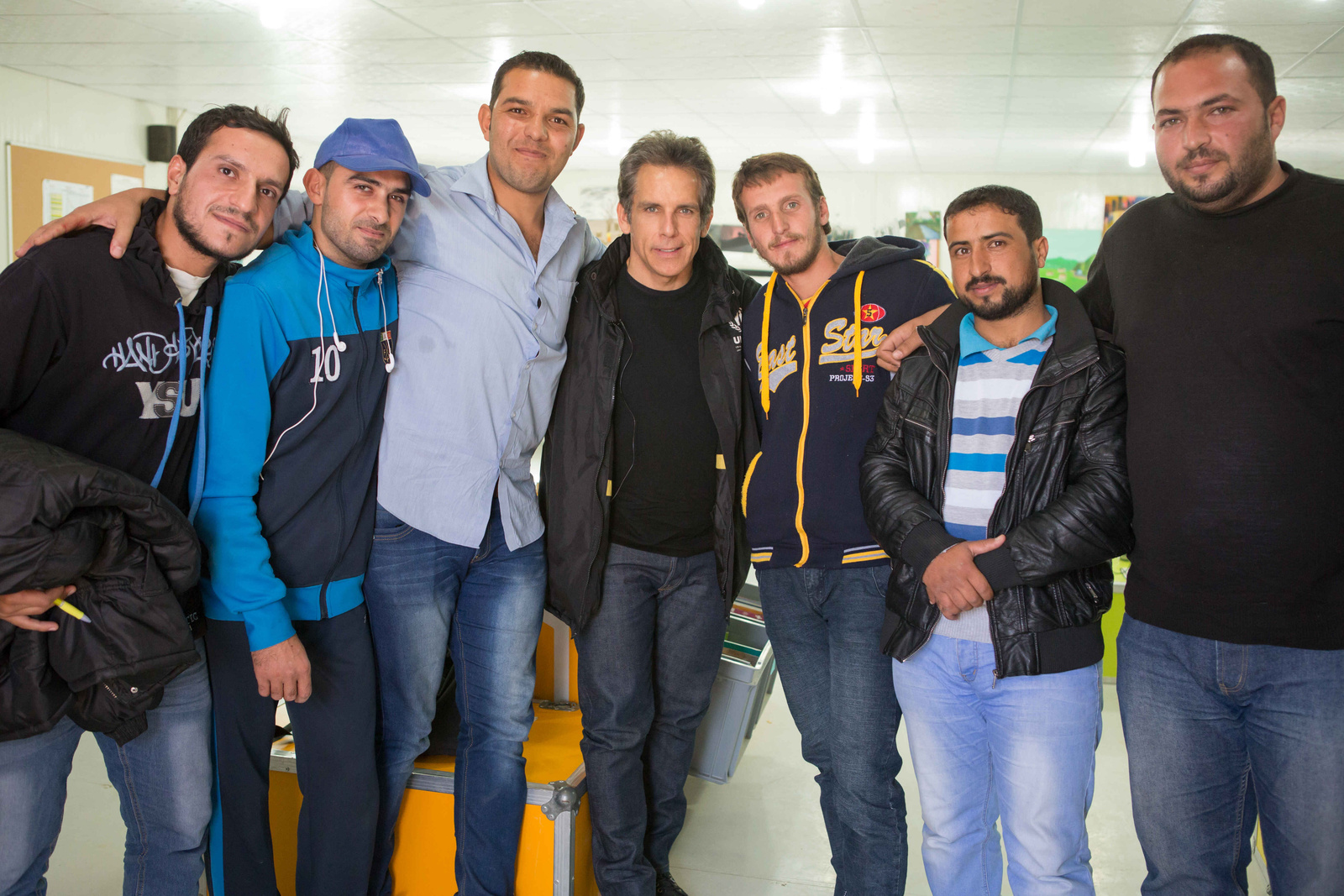 Un grupo de hombres abrazados sonría a la cámara