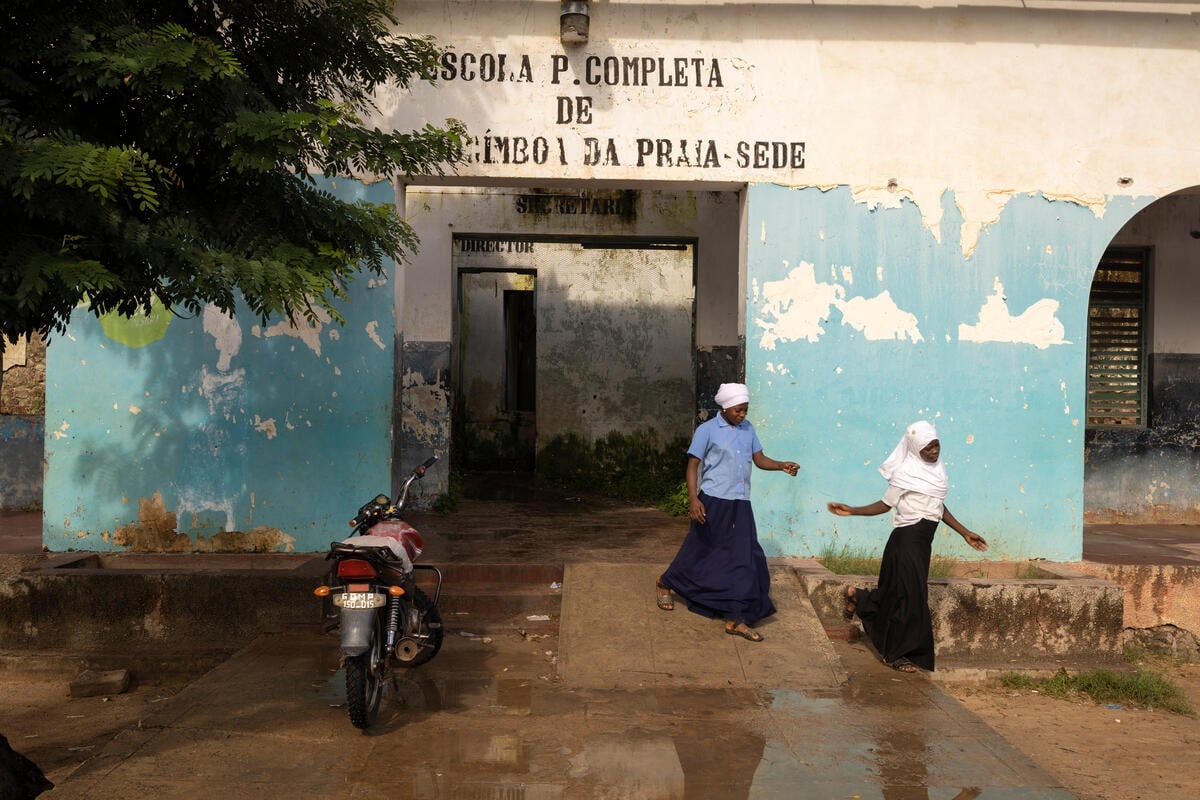 Dos chicas caminan en el exterior de una escuela