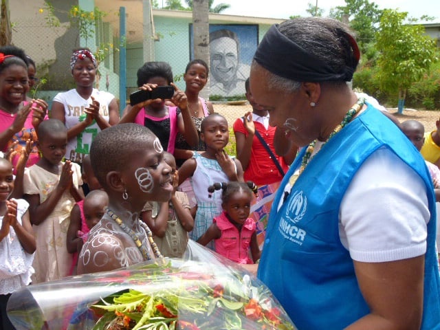 Una niña negra da la bienvenida, con un ramo de flores, a una mujer afroestadunidense