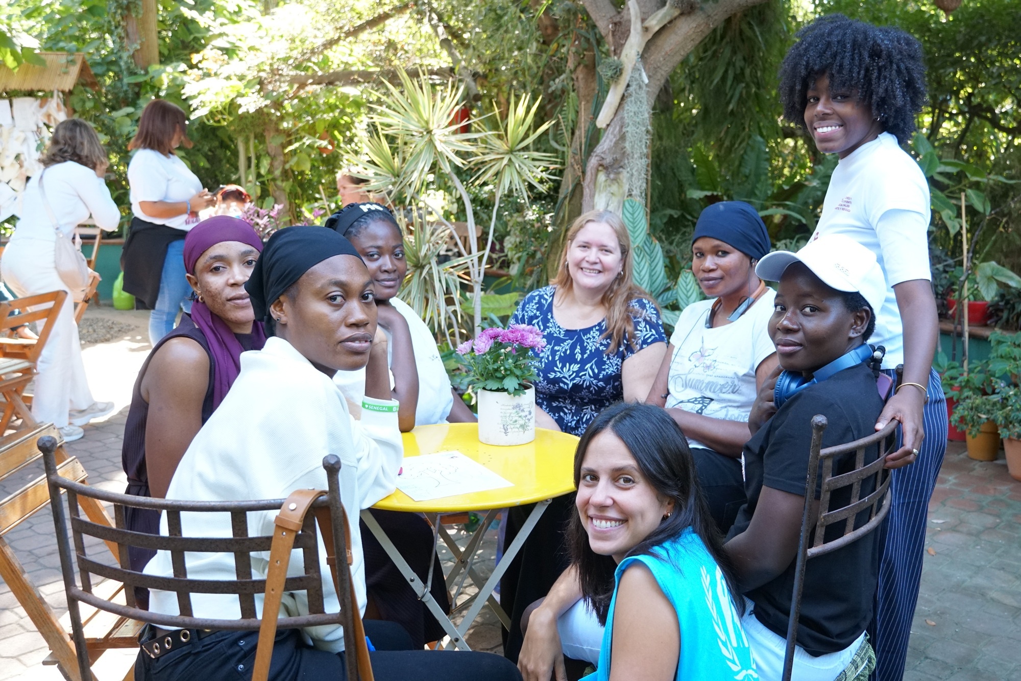 Un grupo de mujeres sentadas en torno a una mesa en un jard&iacute;n.
