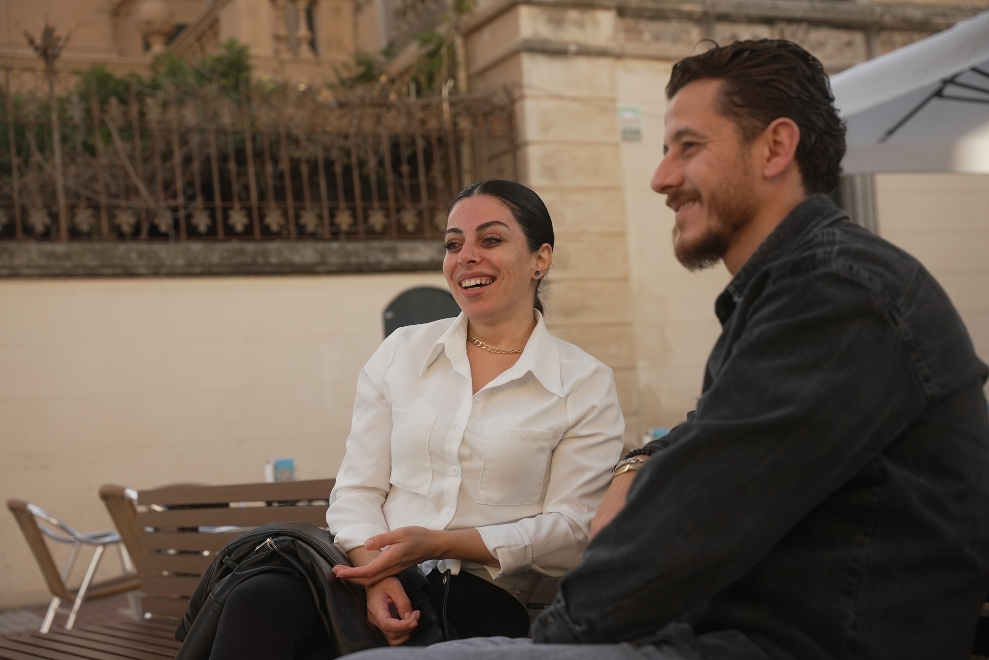 Noura y Raed sentados en una plaza de Calella, Barcelona.
