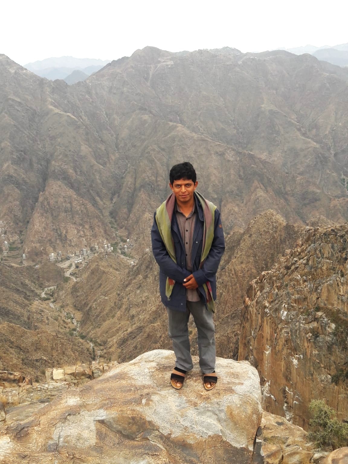 Yousef posa en un paisaje rodeado de monta&ntilde;as.