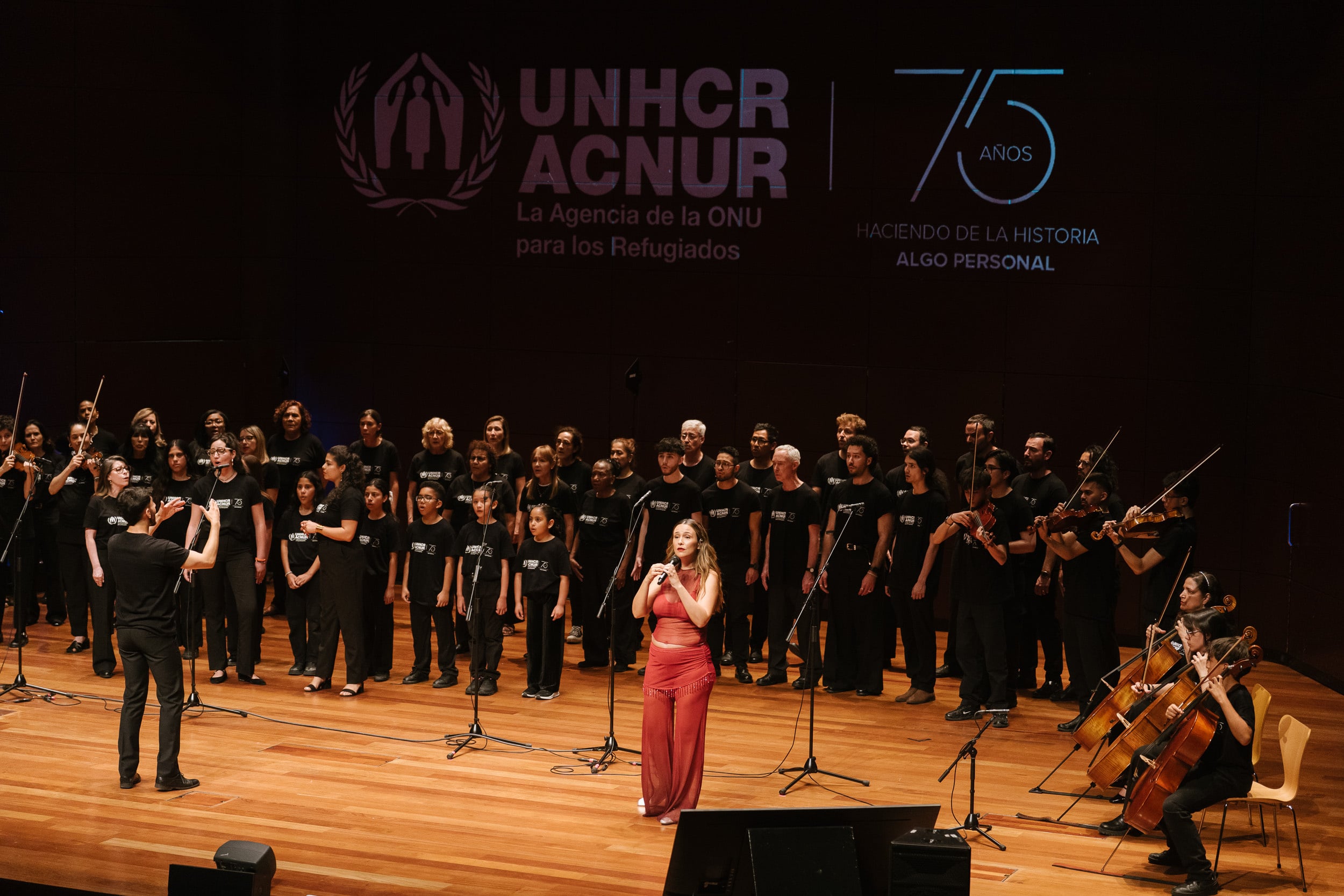 El coro y orquesta M&uacute;sica Sin Fronteras, durante su actuaci&oacute;n con Rigoberta Bandini, en la conmemoraci&oacute;n del D&iacute;a Mundial del Refugiado en el Museo Reina Sof&iacute;a de Madrid.