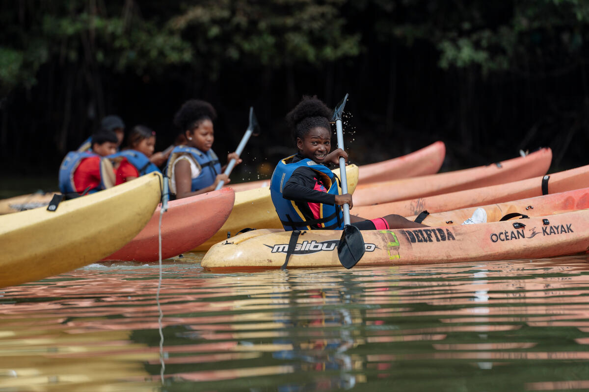 Un grupo de niñas y niños navega en kayak por un río en Ecuador