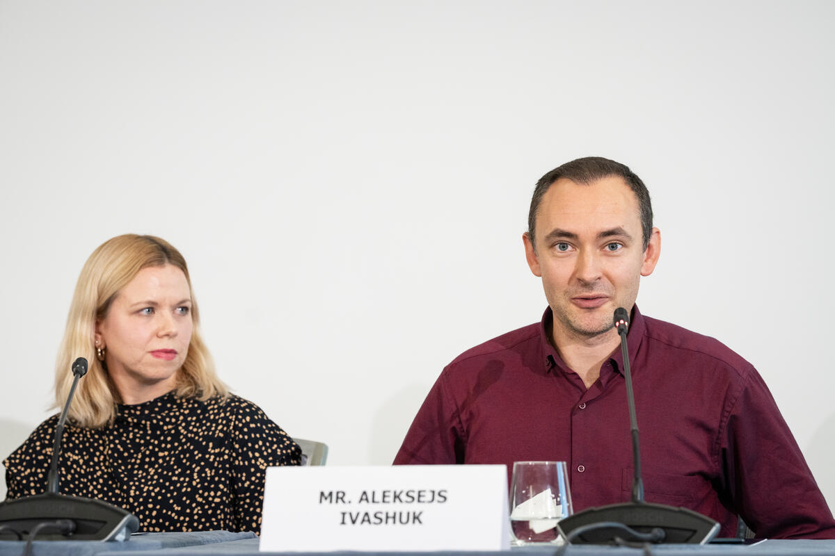 Dos ponentes en un panel, con el nombre del Sr. Aleksejs Ivashuk delante.