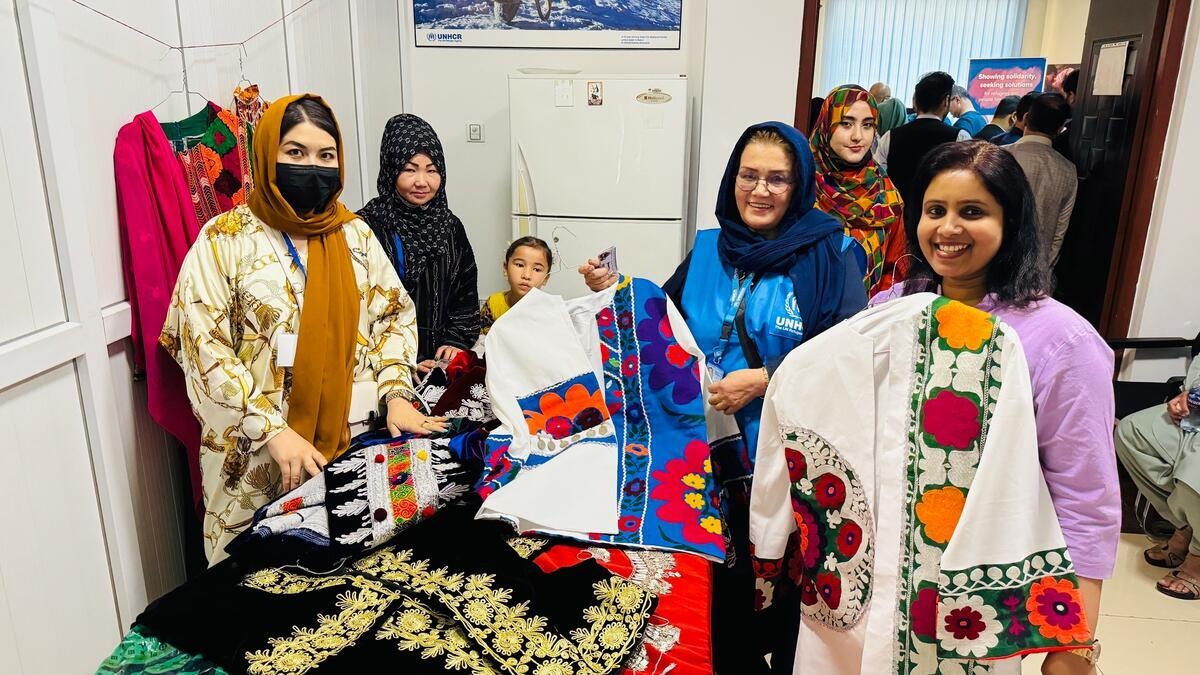 Un grupo de mujeres vestidas con ropa de colores muestran sus productos (ropa).