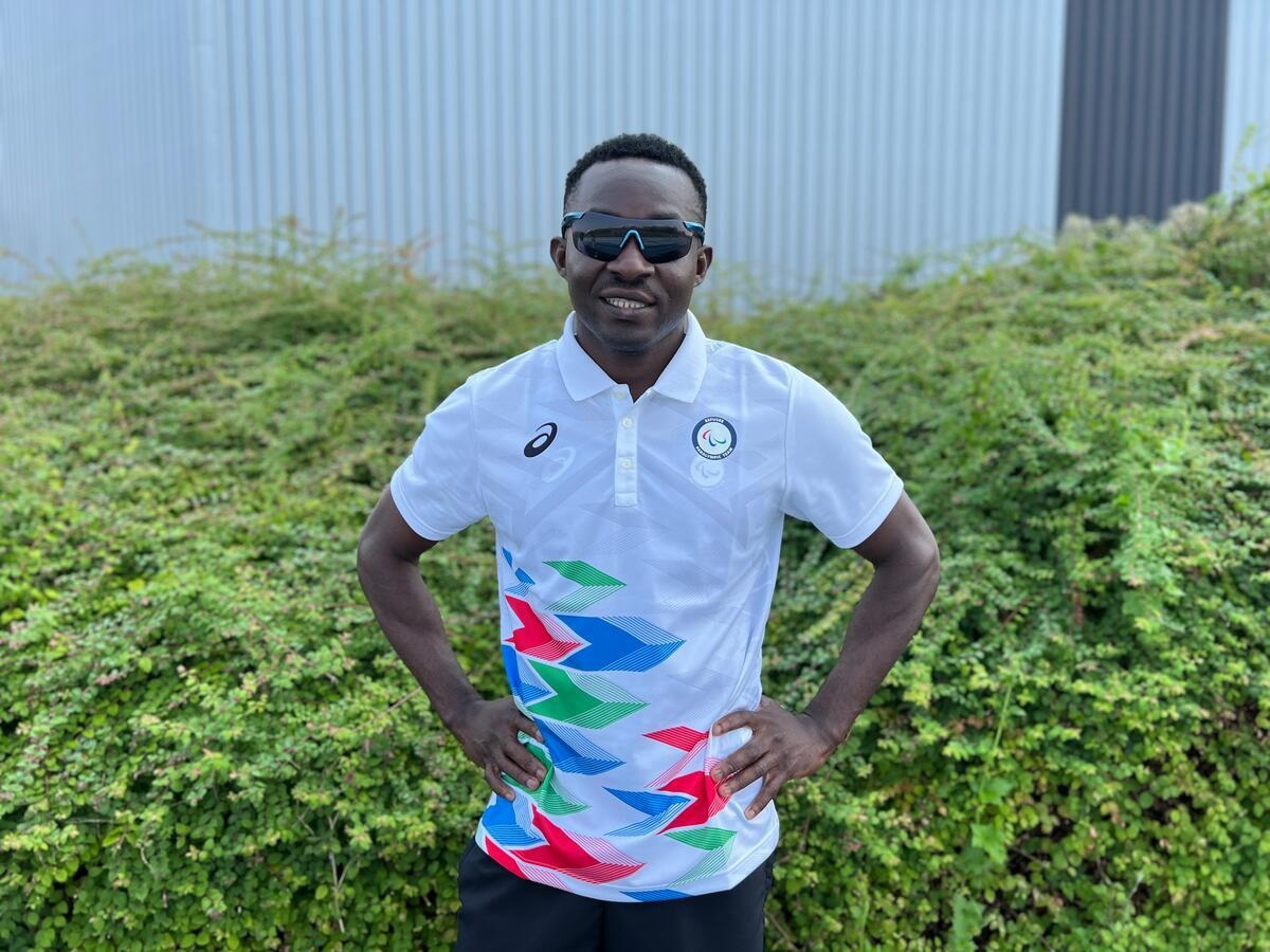 Guillaume Junior Atangana, con lentes de sol, posa para una foto en un campo de entrenamiento en Reims, Francia.