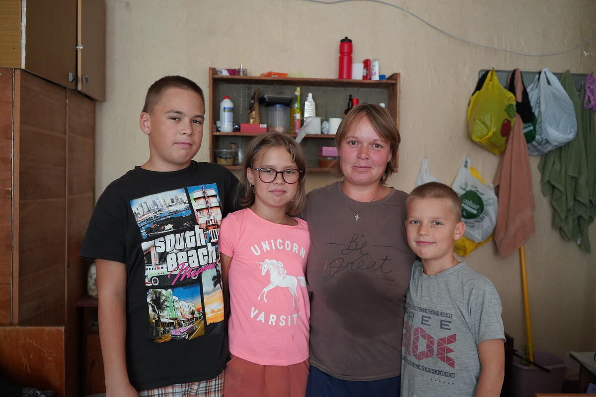 Una madre y sus tres hijos permanecen abrazados dentro de su casa