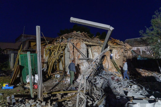 Varias personas evalúan los daños en edificios residenciales de Járkov tras los ataques aéreos del 2 de octubre de 2026.
