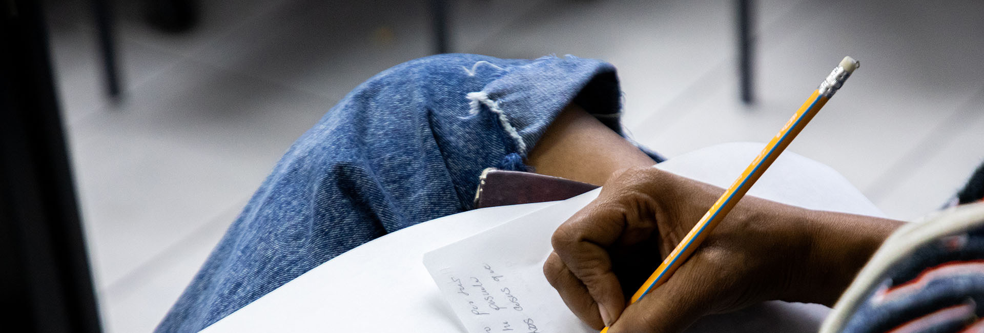 Primera plana de una mano escribiendo una carta.