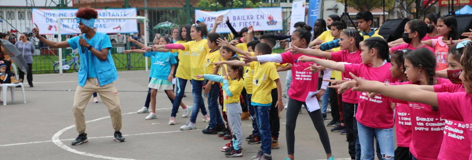 Niñas y niños bailan y cantan durante una actividad para el Día Mundial del Refugiado en Bogotá, Colombia.