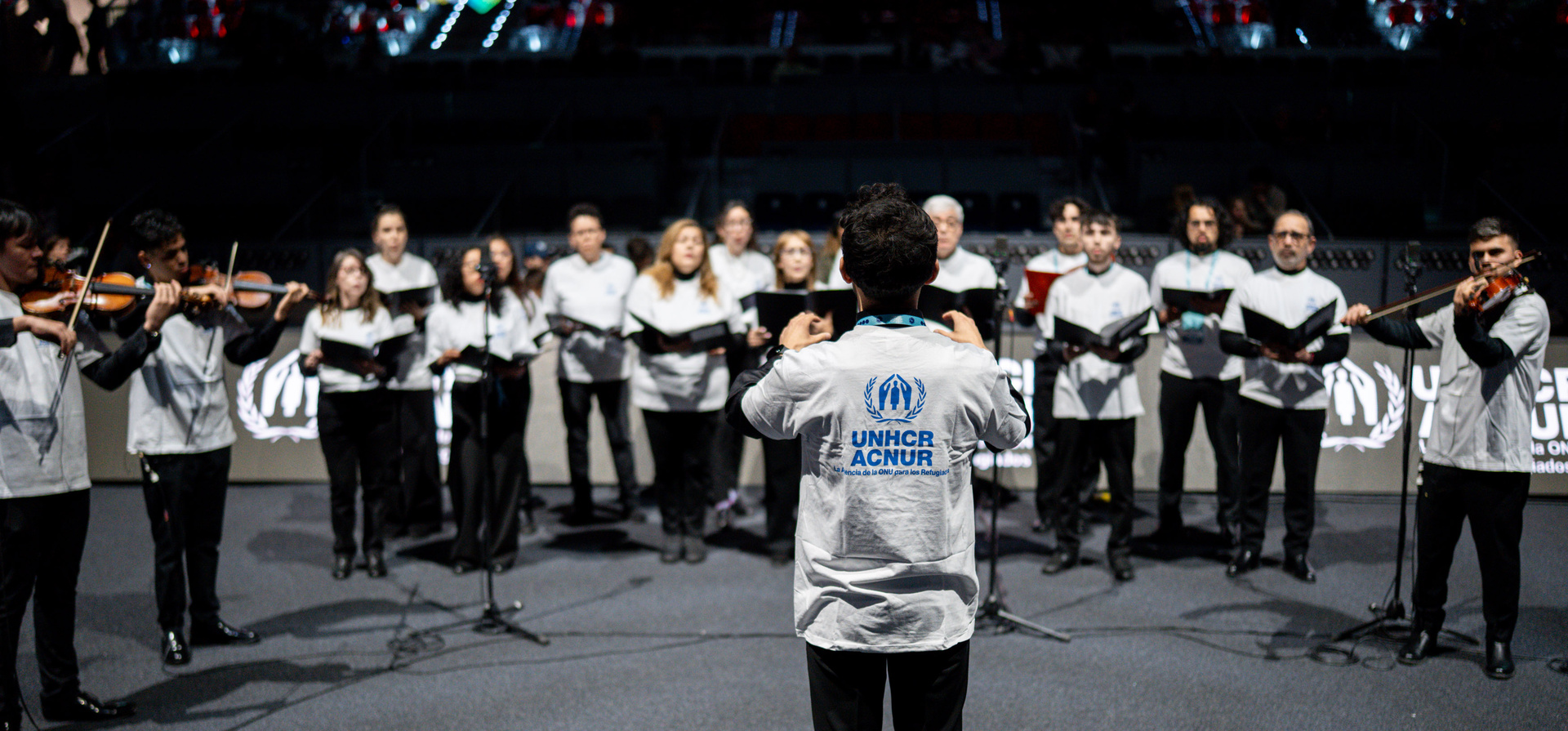 El coro y orquesta Música Sin Fronteras, formado por personas refugiadas y voluntarias, durante su actuación en la GENERALI Hexagon Cup, celebrada en la Caja Mágica de Madrid.