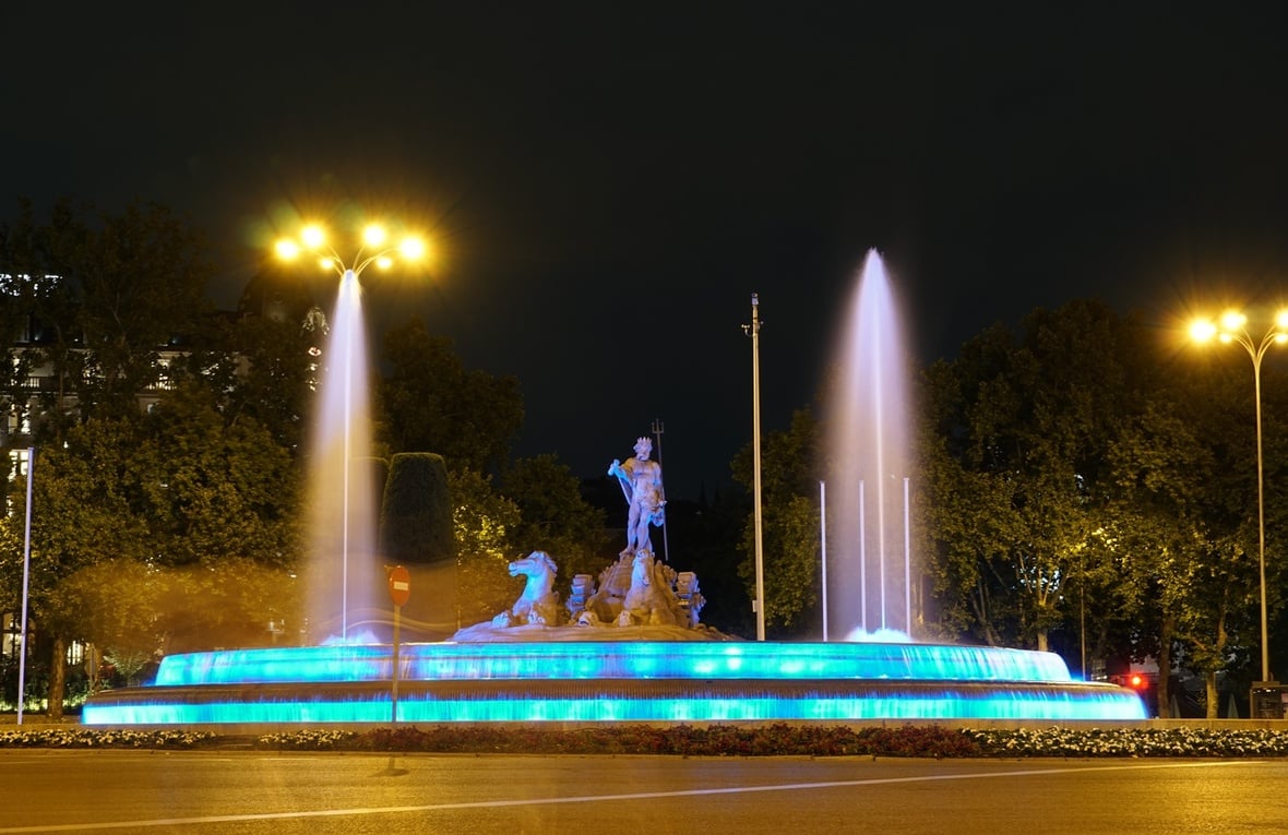 La fuente de Neptuno, en Madrid, iluminada de azul.