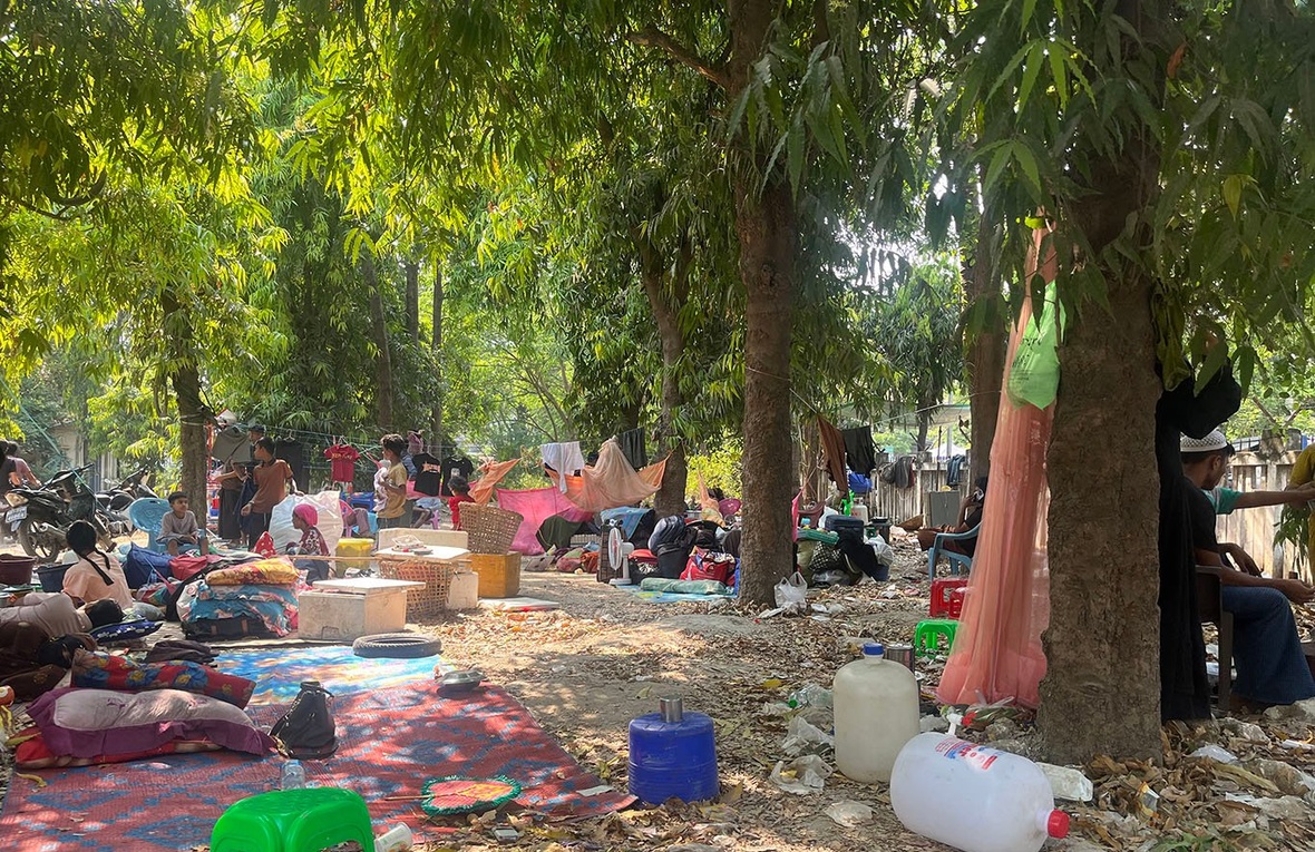Familias desplazadas de sus hogares por el terremoto que golpeó Myanmar el 28 de marzo se refugian en una zona arbolada.