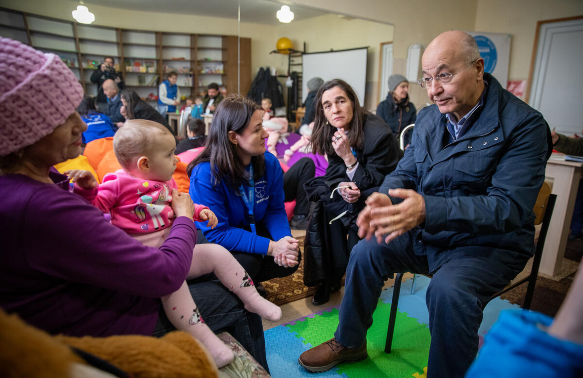 El Alto Comisionado de la ONU para los Refugiados, Barham Salih (a la derecha), habla con Nina (a la izquierda) en un centro de tránsito en Zaporizhzhia, al sureste de Ucrania, después de que ella fuera evacuada de su casa dañada por las bombas junto con su hija y sus tres nietos.