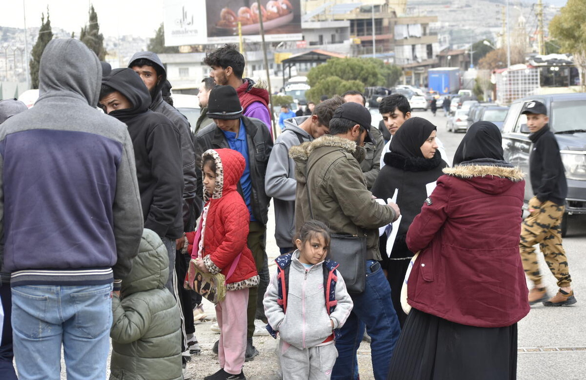 Un grupo de personas espera en el paso fronterizo de Masnaa, en el Líbano, para cruzar hacia Siria.