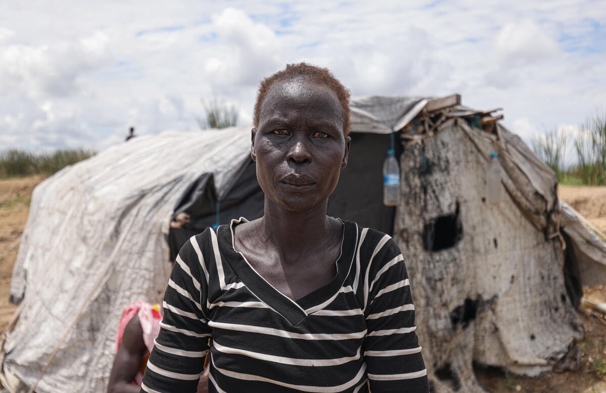 Aduot Wuoi Monjuon, desplazada interna, posa junto a su refugio en Bor, Sudán del Sur, donde se ha desplazado después de que las inundaciones la obligaran a huir de su aldea en el Estado de Jonglei, junto a su familia.