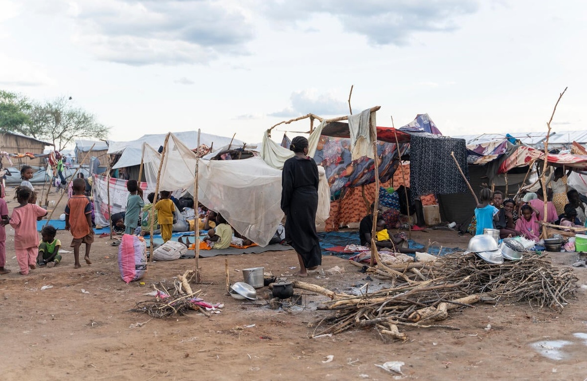 Unos niños caminan sobre un la tierra en un centro de tránsito