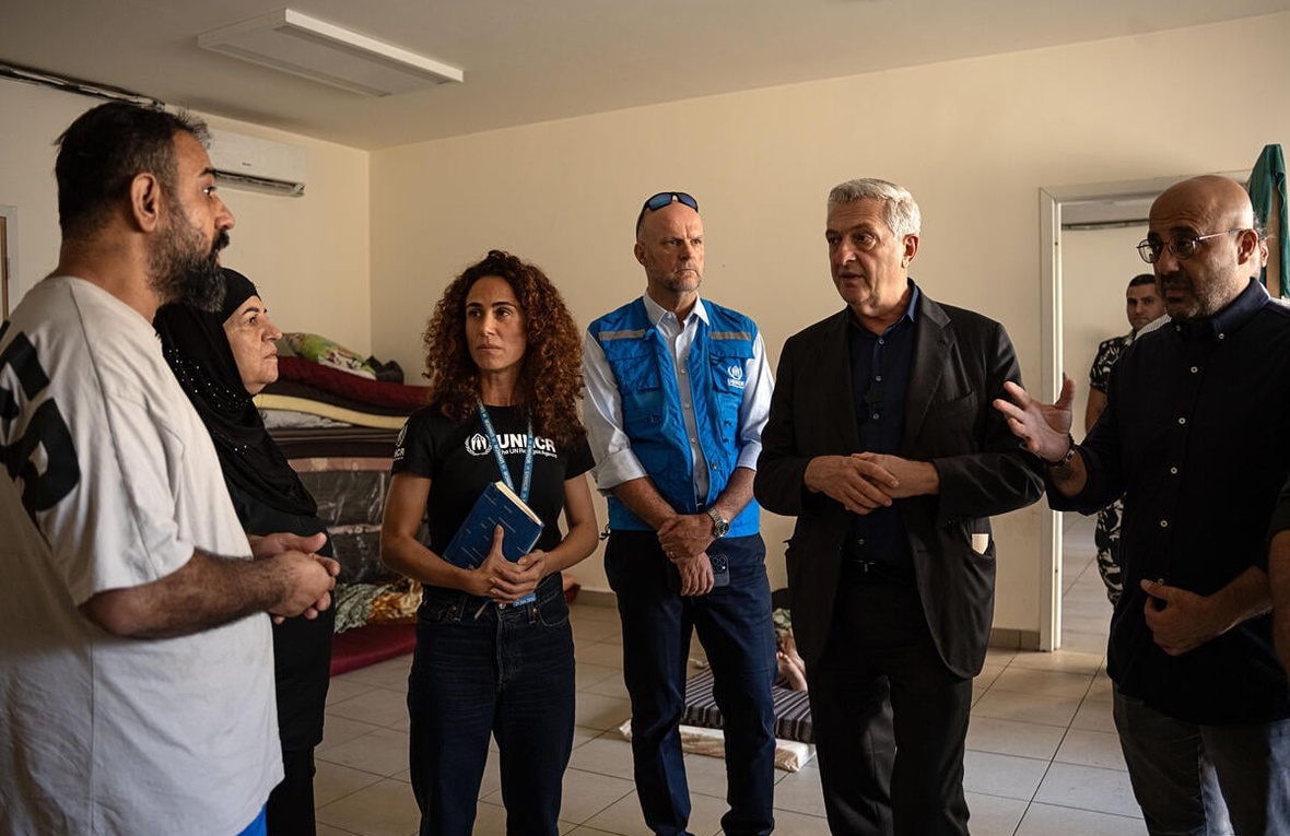 El Alto Comisionado de la ONU para los Refugiados, Filippo Grandi, el ministro de Medio Ambiente libanés, Nasser Yassin, y parte del equipo de ACNUR hablan con una familia libanesa desplazada en un aula de una escuela de Beirut donde se alojan, el viernes 6 de octubre.