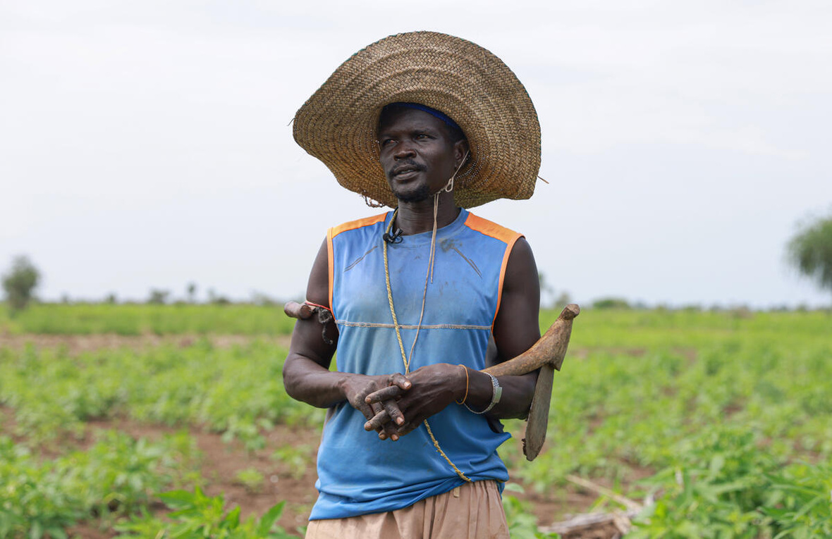 Un hombre con un gran sombrero de paja en un campo
