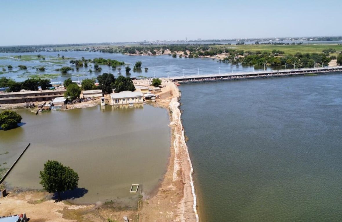 Las inundaciones rodean edificios, árboles y un largo puente