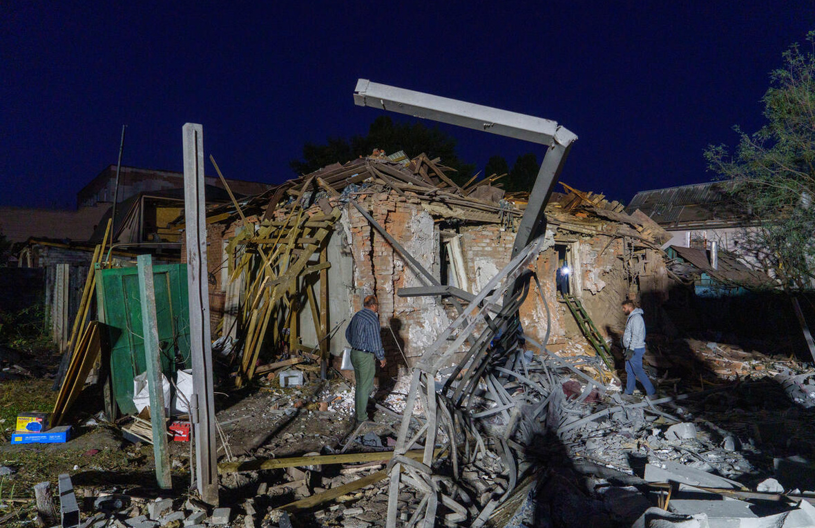 Varias personas evalúan los daños en edificios residenciales de Járkov tras los ataques aéreos del 2 de octubre de 2026.