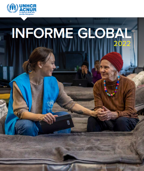 Portada del informe global de ACNUR de 2022. En ella aparece una trabajadora de ACNUR charlando con una mujer mayor en un albergue.