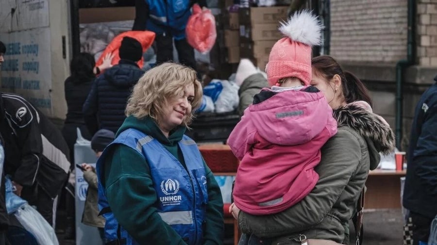 Anzhela, 24 años, carga a sobrina Liliya, de 4 años, mientras están en fila para recibir ropa de abrigo y mantas.