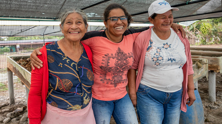 Omaira, Maura y María Pilar, tres refugiadas colombianas en el norte de Ecuador, en un momento de descanso en el espacio donde realizan el cultivo orgánico de hortalizas, una actividad que une a la comunidad local y a las personas refugiadas.