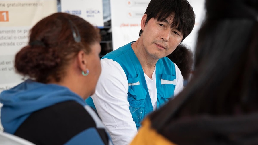 El Embajador de Buena Voluntad de ACNUR Jung Woo-sung habla con personas refugiadas y migrantes en tránsito en el Puinto Wash de Julio Andrade, en Ecuador.