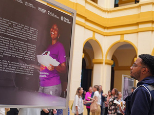 Un joven mirando un panel fotográfico y textual en una exposición.