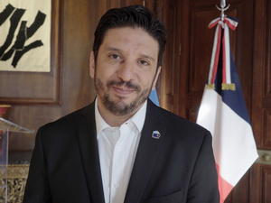 Retrato de un hombre con barba que viste camisa blanca y saco negro