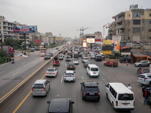 Vista de lo alto de una carretera atestada de vehículos que se dirigen hacia la misma dirección.
