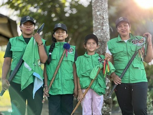 Dos mujeres adultas y dos niñas con los chalecos verdes de Guardia Indígena y los bastones de autoridad.