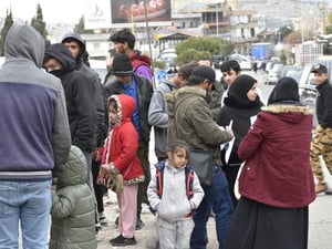 Un grupo de personas se reúnen en el paso fronterizo de Masnaa, en el Líbano, mientras espera cruzar a Siria para escapar de los bombardeos israelíes en curso y de las órdenes de evacuación.