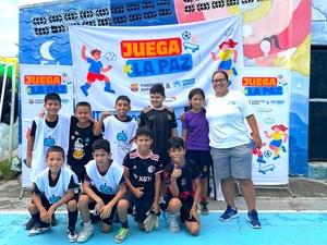 Un grupo de ocho niños, una niña y una mujer adulta con uniformes deportivos